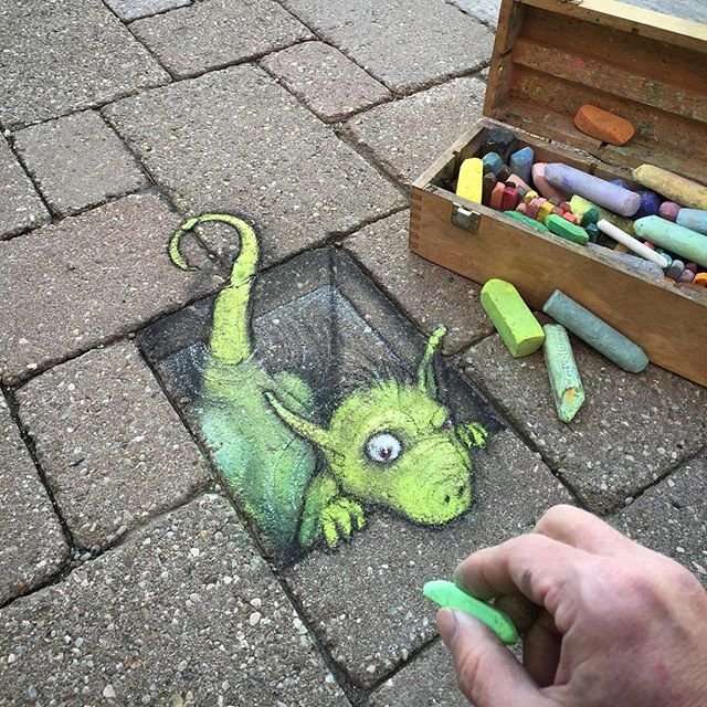 Художник рисует мелом забавных персонажей на улицах города